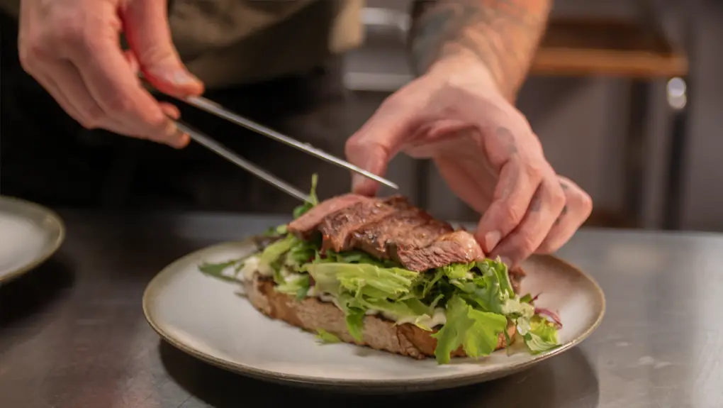 Kokk som lager biffsandwich på Honne hotell